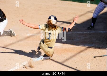 A Baseball Player is Sliding at Home Plate Stock Photo