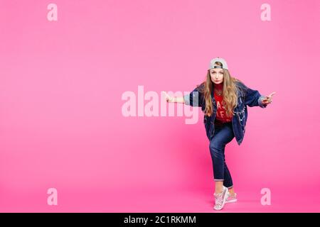 Young model wearing jeans outfit and posing in pink studio. Stock Photo