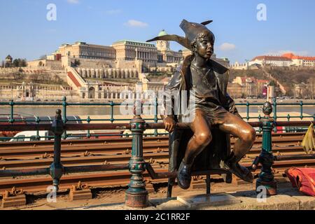 Budapest, Hungary, March 22 2018: Statue of a sitting child with a hat near the tram rail on the banks of the Danube Stock Photo