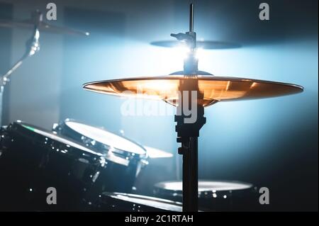 Close-up Drum set in a dark room against the backdrop of the spotlight. Atmospheric background symbol of playing rock or jazz dr Stock Photo