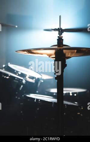 Close-up Drum set in a dark room against the backdrop of the spotlight. Atmospheric background symbol of playing rock or jazz dr Stock Photo