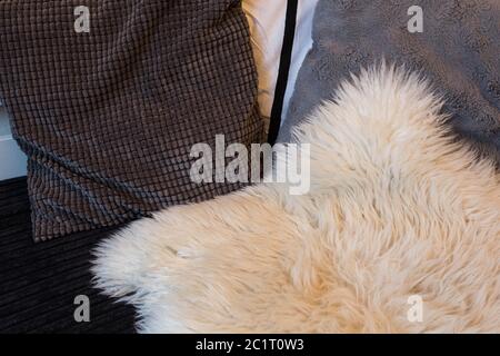 Grey pillows on sofa close up with wool blanket Stock Photo