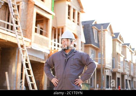 Male builder wearing hardhat standing on construction site in Canada. Stock Photo