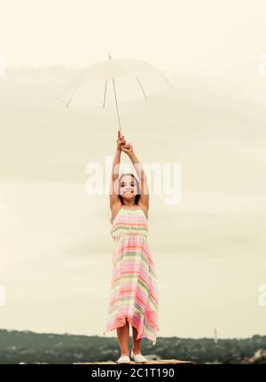 Fairy tale character. Feeling light. Girl with light umbrella. Anti gravitation. Fly drop parachute. Dreaming about first flight. Kid pretending fly. Happy childhood. I believe i can fly. Touch sky. Stock Photo