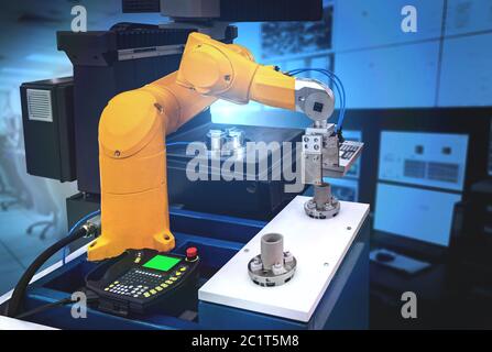 Industry and technology,Robot arm process picking metal part up and placing it in CNC machine.Robotic industrial Stock Photo