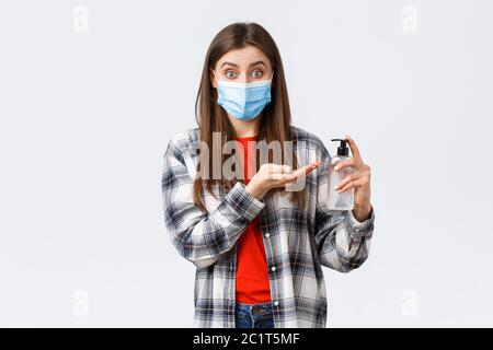 Coronavirus outbreak, leisure on quarantine, social distancing and emotions concept. Smiling girl preventing catching virus, wear medical mask and Stock Photo