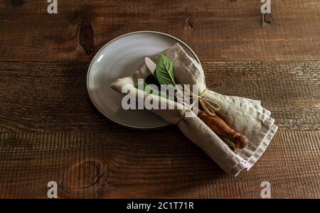 Set of cutlery knife, spoon, fork with linen napkin on the plate. Stock Photo