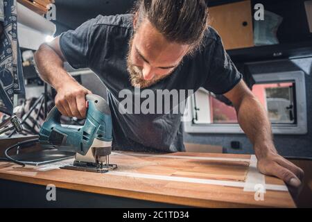 Man working on the countertop inside a camper van Stock Photo