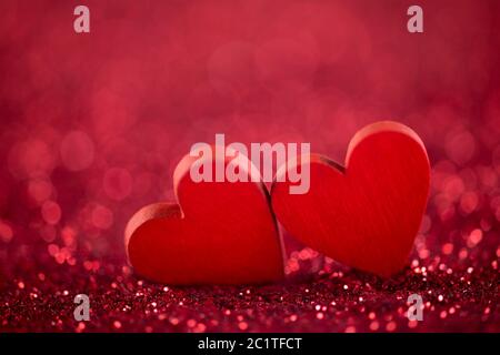 Two red hearts on glitter background in love concept Stock Photo