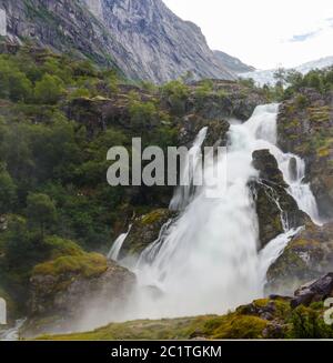 Panoramic view to kleivafossen waterfall at briksdalselva river, Briksdalsbreen glacier, Norway Stock Photo