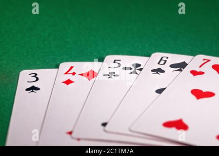 playing cards on the green table. Combination "Straight" in poker Stock Photo
