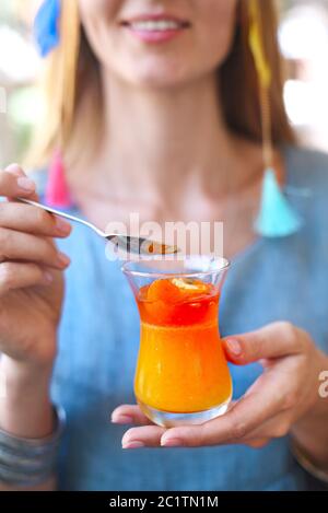 Woman eating citrus cumquat jelly dessert Stock Photo