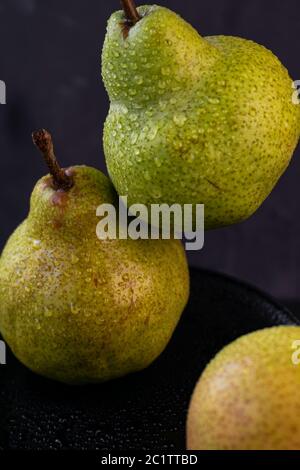 selective focus: large ripe pears with water drops on a dark background Stock Photo
