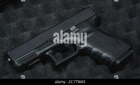 Handgun pistol laying in a protective case with black foam at the shooting range.  Stock Photo
