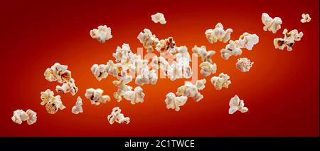 Popcorn isolated on red background. Falling or flying popcorn. Close-up Stock Photo