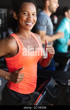 Group of young people running on treadmills in sport gym Stock Photo