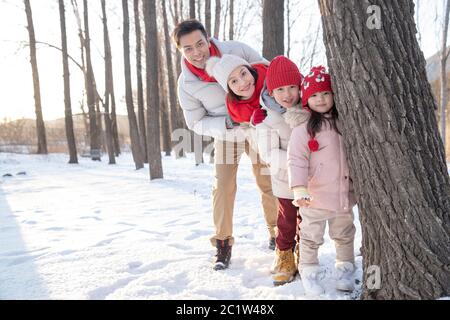 Happy family playing in the snow Stock Photo