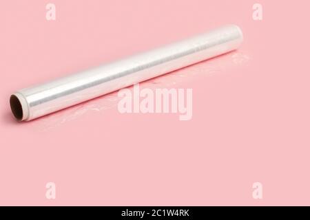 A roll of wrapping plastic stretch film on a pink background Stock Photo