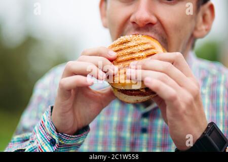 Close-up of man biting hamburger. Stock Photo