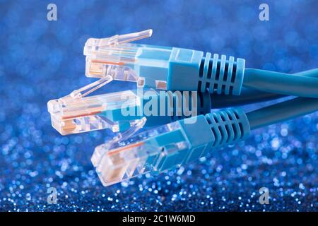 Three network cables over blue sparkles background Stock Photo