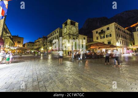 KOTOR, MONTENEGRO - 13TH AUGUST 2016: Views along streets of Old Town Kotor at night. The outside of buildings, restaurants and people can be seen. Stock Photo
