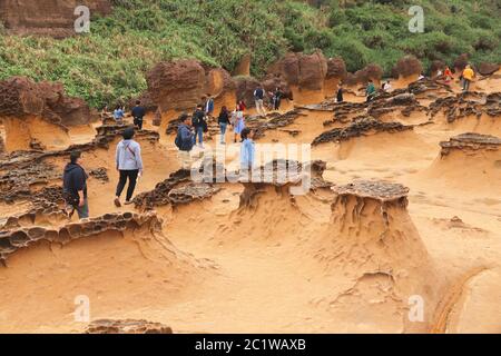 YEHLIU, TAIWAN - NOVEMBER 24, 2018: People visit Yehliu Geopark in Taiwan. Yehliu is a popular tourism destination with peculiar natural rock forms Stock Photo