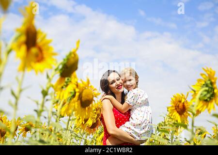 Mother and her little daughter in the sunflower field Stock Photo