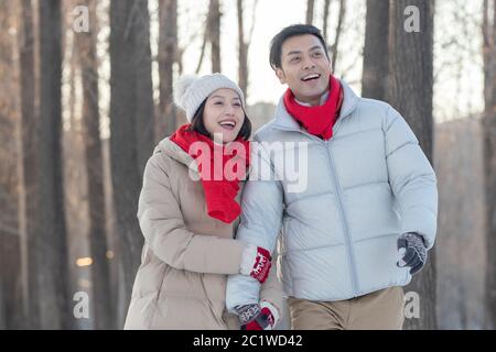 The young couple walking on the snow Stock Photo