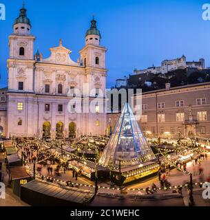 High view showing part of the Salzburg Christmas Market with the Fortress Hohensalzburg in the distance and Salzburg Cathedral in the foreground Stock Photo
