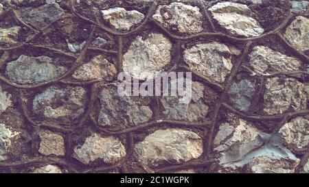 Wall of large stones with thick seams, rubble background. Stock Photo
