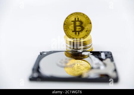 Stack of Gold bitcoin tokens on top of an open hard drive.Worldwide virtual internet cryptocurrency,digital payment system.Concept Digital coin money Stock Photo