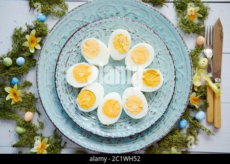 Easter table setting with flowers and eggs. Decorative plates with boiled eggs Stock Photo