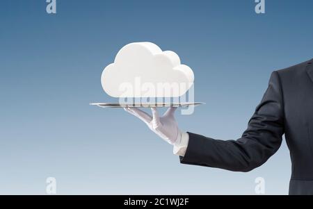 Businessman offering white cloud on silver tray over blue background Stock Photo