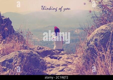 Inspirational Typographic Quote Waiting for you. Vintage photo of lonely  Young woman sitting on mountain. Rear view Stock Photo