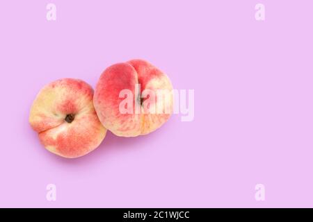 Chinese flat peaches on pink background. Copy space Stock Photo