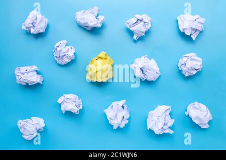 White with yellow crumpled paper balls on a blue background. Top view Stock Photo