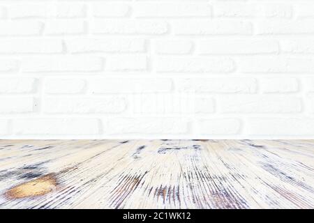 washed wood table with white brick wall texture background. Stock Photo