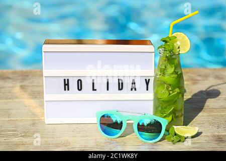 Light letterbox with word Holiday, hat, sunglasses and Mojito cocktail with lime Stock Photo