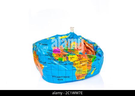 Planet earth toy balloon deflated isolated on white background. Earth overshoot day, unsustainable resources consumption concept Stock Photo