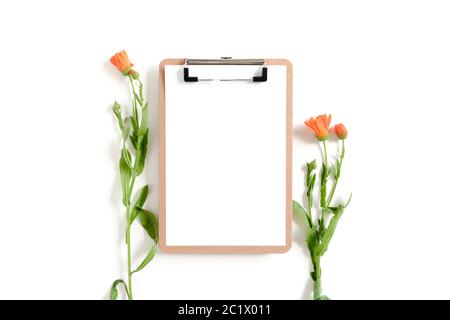 Clipboard mockup with calendula flowers on white desk Stock Photo
