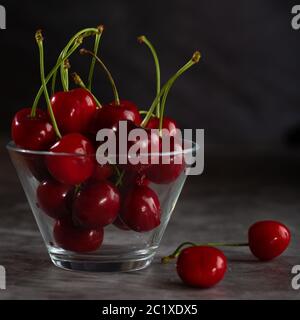 Two cherries on the table and bowl full of cherries Stock Photo