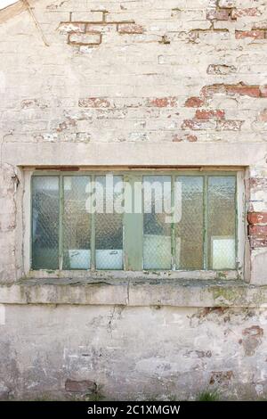 Old window in a delapidated brick built shed Stock Photo