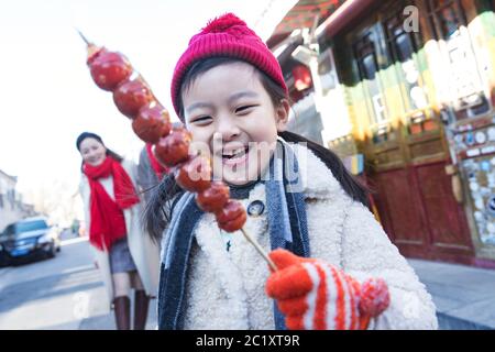 Happy little girl eat sugar-coated berry Stock Photo
