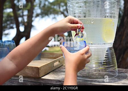 Kid pouring lemonade on the candy bar Stock Photo