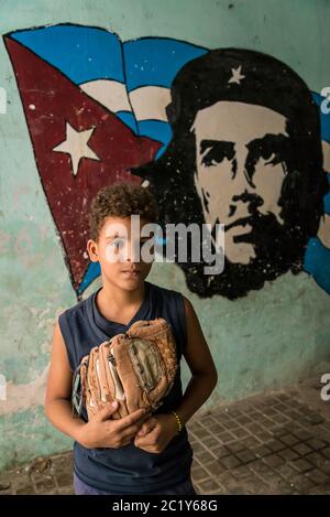 Boy next to Che Guevara wall painting , Old City Centre, Havana Vieja, Havana, Cuba Stock Photo