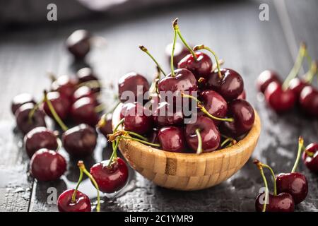 Fresh cherries washed in clean water in a bowl and scattered all around Stock Photo