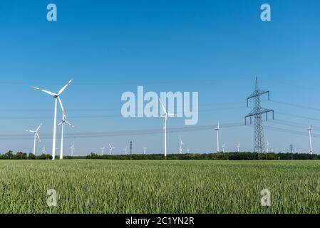 Wind turbines and an overhead power line in Germany Stock Photo