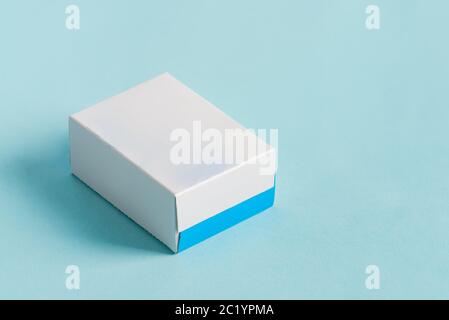 Handmade mock up paper box for package products and goods on a light blue background with soft shadows. Stock Photo