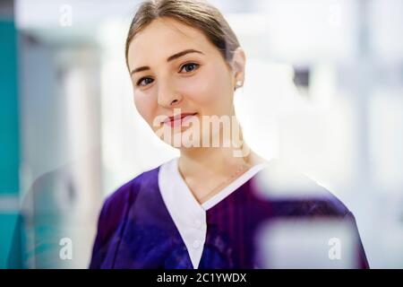 Portrait of pretty woman in cleaning service uniform looking at camera. Stock Photo