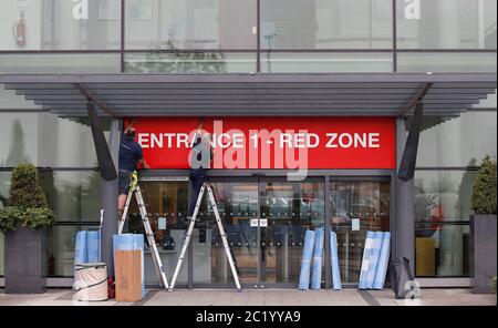 Workmen place signs at main entrance to the Etihad Stadium, home of Manchester City. The Premier League restarts tomorrow night with Aston Villa v Sheffield United and Manchester City v Arsenal. Stock Photo